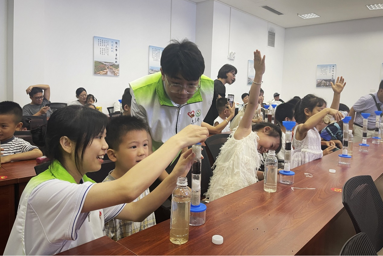 “创智联`志愿者在科普厅与小朋友一起完成净水小实验
