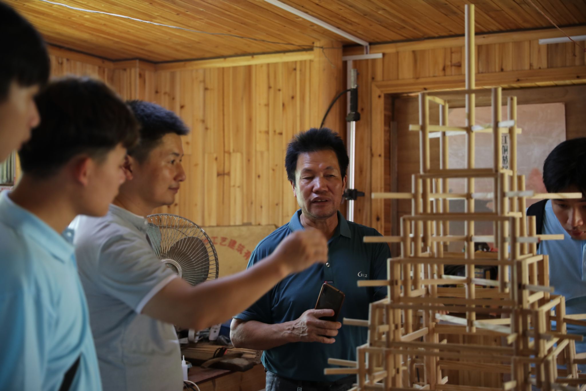 杨似玉大师利用鼓楼模型向实践团成员解说鼓楼开云线上平台_开云（中国）结构